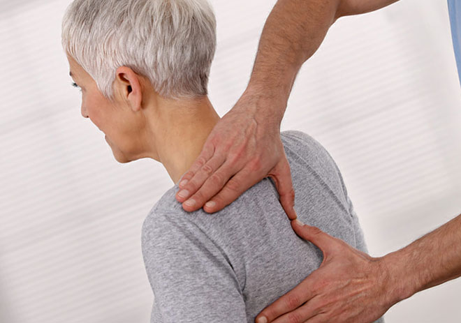 женщину с грудным остеохондрозом осматривает врач