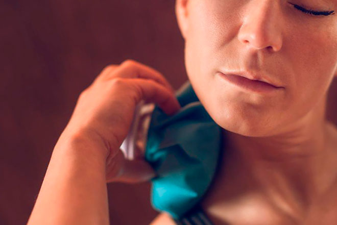 девушка прогревает шею компрессом