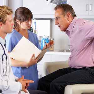 Older adult in pain with physician